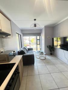 a living room with a black couch in a kitchen at Lagoon escape Apartment in Pretoria