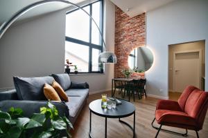 a living room with a couch and a table at Calma - apartamenty z ogrodem blisko Energylandii in Zator