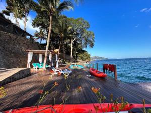 a dock with chairs and a boat on the water at Angra dos reis Serra e Mar in Angra dos Reis