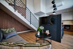 a living room with a couch and a table at Calma - apartamenty z ogrodem blisko Energylandii in Zator