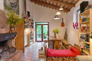 a living room with a fireplace and a red couch at Agri Ostello Valle Libera in Chianaiola