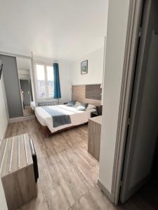 a bedroom with a bed and a large window at Logis - Hôtel du Nord et Restaurant La Table d'Elisa in Compiègne