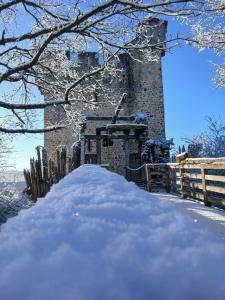 a building covered in snow next to a fence at Domaine de la Ferté Clairbois in Sainte-Suzanne