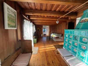 a living room with wooden ceilings and a room with a couch at Haus Bergsteigerglück in Schleching