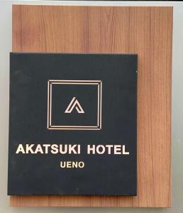 a black hotel sign on a wooden door at AKATSUKI HOTEL Ueno JR山手線鶯谷駅まで徒歩3分 成田空港直行 新宿渋谷直通 in Tokyo