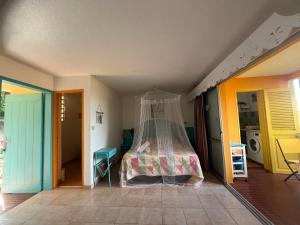 a bedroom with a bed with a mosquito net at Ti' Cocon Caritan in Sainte-Anne +4 photos