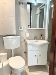 a white bathroom with a toilet and a sink at La Casa del Sole in Corleone +29 photos