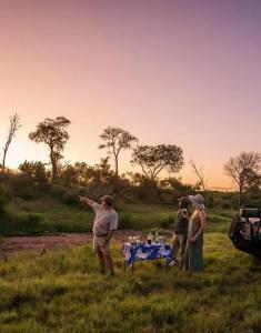 a group of people standing around a table in a field at Zambezi Dream Cruiser in Victoria Falls