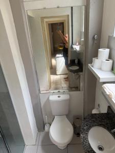 a person taking a picture of a bathroom with a toilet at Apartamento central com pátio, 1 quadra do calçadão in Santa Maria +4 photos