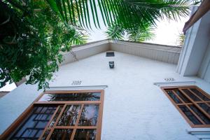 a building with two windows and a palm tree at Tunji Homestay in Arusha