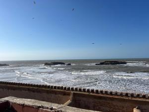a view of the ocean with rocks in the water at Riad Sor in Essaouira +51 photos