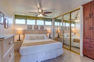 a bedroom with a bed and a ceiling fan at Hale Ono Loa 204 in Lahaina +5 photos
