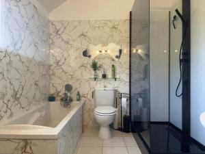 a bathroom with a toilet and a tub and a sink at Chambre Morgon in Savines +34 photos