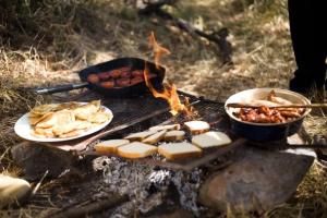 a grill with two plates of food and two pans of food at Zambezi Dream Cruiser in Victoria Falls