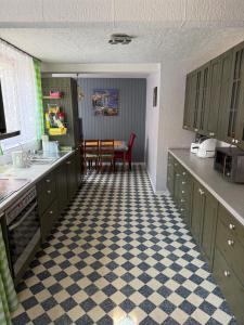 a kitchen with green cabinets and a checkered floor at Zimmervermietung Kimberly in Bischbrunn