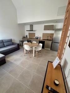 a kitchen and a living room with a table and chairs at Maison individuelle meublée in Chaignay