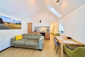 a living room with a couch and a table and a kitchen at Apartmány U Kovárny in Horní Blatná