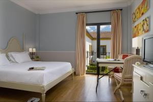 ein Schlafzimmer mit Bett, Schreibtisch und Computer in der Unterkunft AZZ Castellar Hacienda El Alcornocal in Castellar de la Frontera + 69 Fotos