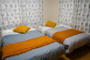 two beds sitting next to each other in a bedroom at TENT OKAYAMA - 3 Bedrooms, 100m2 Private Home for Max 8 people, Ideal for Families and Groups in Hokancho