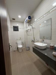 a bathroom with a sink and a toilet and a mirror at Rosie Hotel in Da Thien