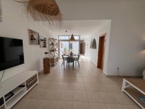 a living room with a table and a dining room at Villa Dinateli, Salinas Golf in Caleta De Fuste