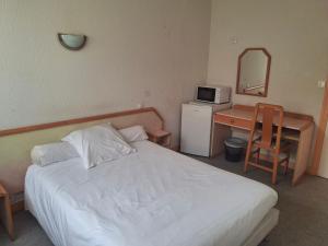 a bedroom with a bed and a desk with a microwave at Maison Jean le Bon in Dax