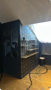 a bathroom with a black wall with mirrors and a window at Love Room in Canteleu