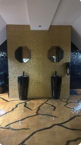 a bathroom with two urinals and two mirrors on a wall at Love Room in Canteleu