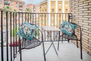 a balcony with two chairs and a table with pillows at Aroma D Valencia Luxury and Designer Apartment in Valencia