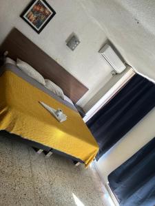 a bedroom with a bed with a yellow blanket at Hotel San Francisco in Villahermosa