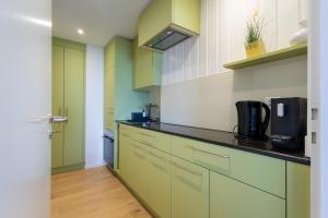 a kitchen with green cabinets and a black counter top at Ferienwohnung Schwyz in Schwyz
