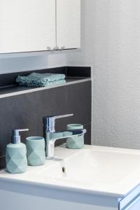 a bathroom sink with two cups and a mirror at Ferienwohnung Schwyz in Schwyz +13 photos