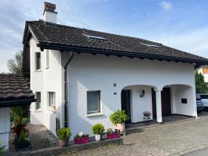 a white house with potted plants on a street at Ferienwohnung Schwyz in Schwyz