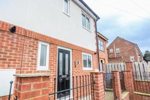 an image of a brick house with a black door at 61 Deneside in Lanchester