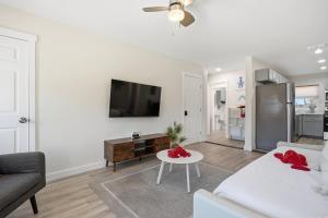 a white living room with a white couch and a tv at 2 Bedroom Unit in Corpus Christi