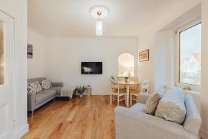 a living room with a couch and a table at The Wee Harbour Home in Anstruther