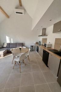 a kitchen with a table and chairs in a room at Maison individuelle meublée in Chaignay