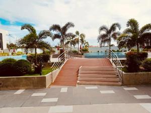 a wooden walkway leading to a pool with palm trees at KEY REALTY SERVICES Ph in Pajak