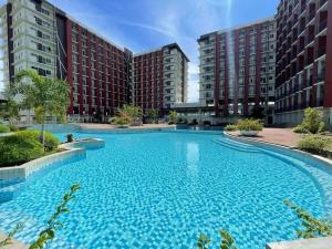 a large blue swimming pool in front of some buildings at KEY REALTY SERVICES Ph in Pajak +4 photos