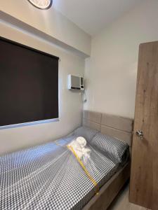 a small room with a bed with a tv on the wall at KEY REALTY SERVICES Ph in Pajak