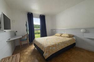a bedroom with a bed and a large window at Hôtel La Croisée Neuchâtel in Malvilliers