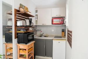 a small kitchen with a sink and a microwave at Doux Pavillon - Le Patio in Nice