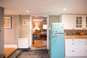 a kitchen with a blue refrigerator and a living room at Hollyhocks, Tunstall in Tunstall