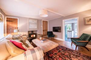 a living room with a couch and a fireplace at Hollyhocks, Tunstall in Tunstall