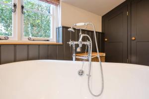 a bath tub with a shower in a bathroom at Hollyhocks, Tunstall in Tunstall +27 photos