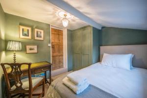 a bedroom with a bed and a desk and a chair at Hollyhocks, Tunstall in Tunstall