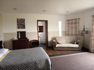 a bedroom with a bed and a couch and a chair at Alice's House in Horta