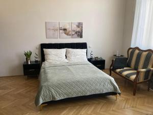 a bedroom with a bed and a chair at LILI Deluxe Apartman in Tapolca
