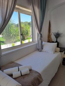 a bedroom with a large white bed and a window at Herdade da Cova da Onça in Canha