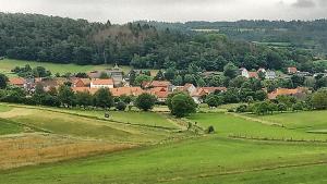 a large green field with a town in the distance at tausend plus eine nacht in Vöhl